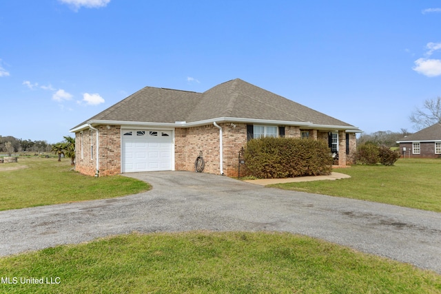 ranch-style home featuring driveway, roof with shingles, a front yard, an attached garage, and brick siding