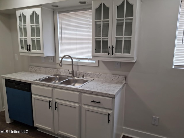 kitchen featuring stainless steel dishwasher, sink, light stone counters, and white cabinets