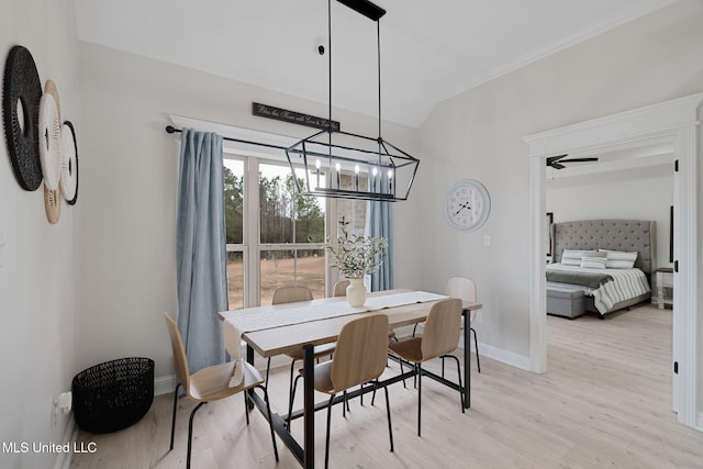 dining space with ceiling fan with notable chandelier and light wood-type flooring