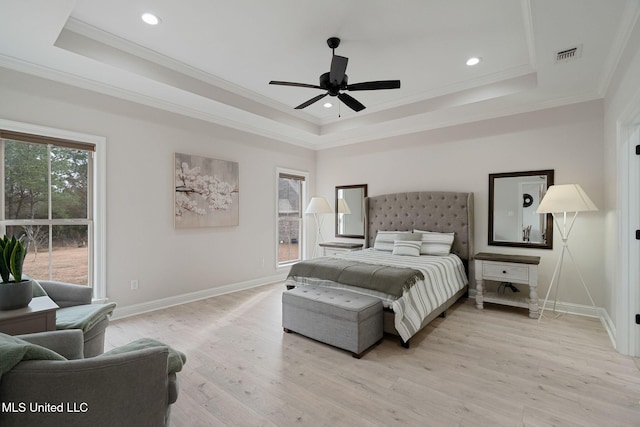 bedroom featuring ceiling fan, ornamental molding, a raised ceiling, and light hardwood / wood-style flooring