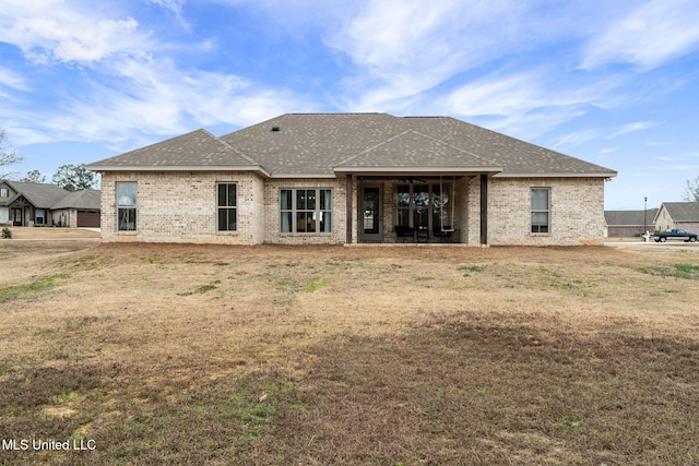 back of property featuring a yard