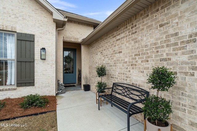 view of exterior entry with a patio