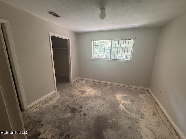 2318 Breckinridge Rd, Jackson, MS 39204 - unfurnished bedroom featuring a textured ceiling, a walk in closet, and a closet