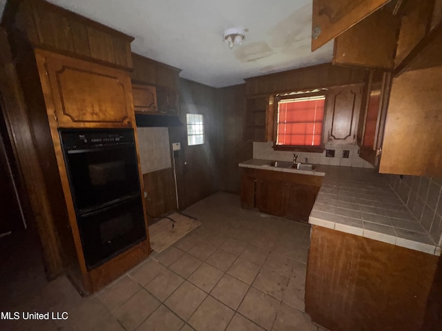 2318 Breckinridge Rd, Jackson, MS 39204 - kitchen with tile counters, light tile patterned flooring, and brown cabinetry