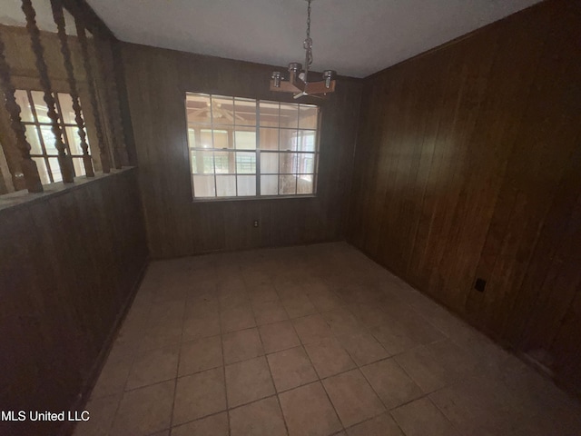 2318 Breckinridge Rd, Jackson, MS 39204 - unfurnished dining area with wood walls, a chandelier, and tile patterned flooring