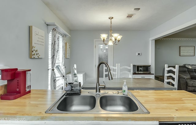 kitchen with an inviting chandelier, sink, and decorative light fixtures