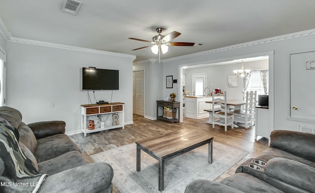 living room featuring crown molding, ceiling fan with notable chandelier, and hardwood / wood-style floors