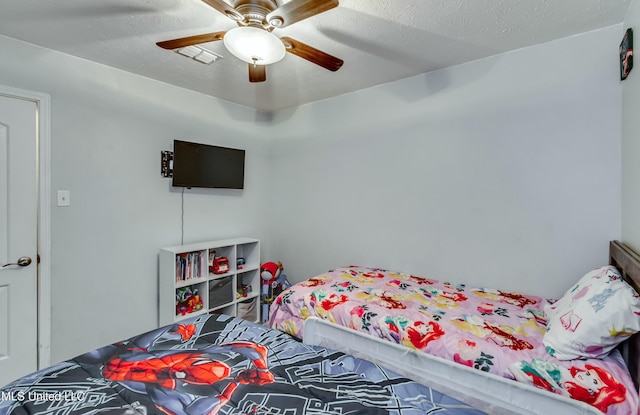 bedroom featuring ceiling fan and a textured ceiling