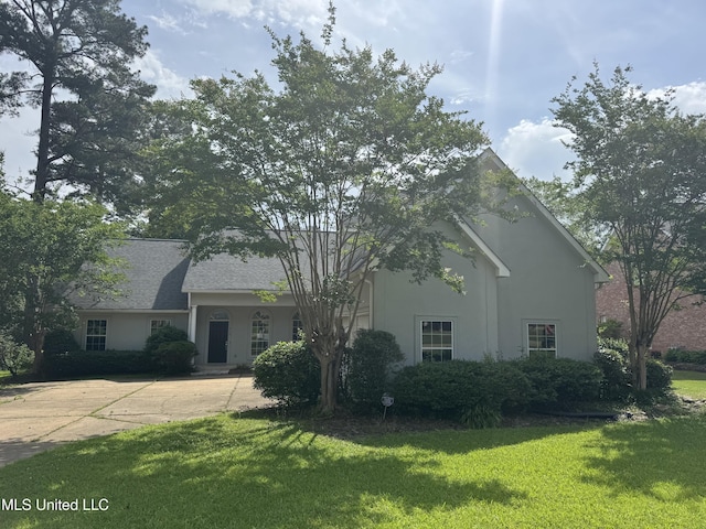 314 Fox Holw, Canton, MS 39046 - view of property hidden behind natural elements with a front yard, stucco siding, and concrete driveway