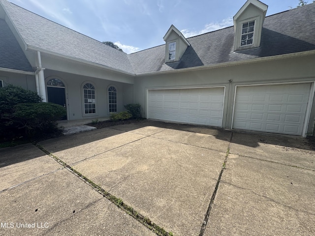 314 Fox Holw, Canton, MS 39046 - view of front of house with driveway, a garage, a shingled roof, and stucco siding