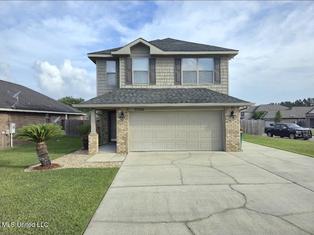 traditional-style home featuring fence, an attached garage, driveway, and a front lawn