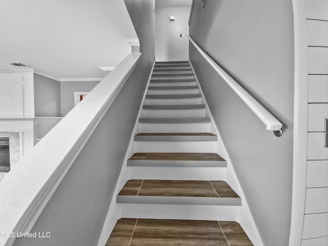 stairway featuring visible vents and ornamental molding