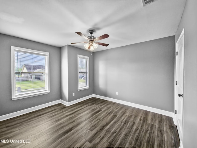 unfurnished room with baseboards, ceiling fan, and dark wood-style flooring