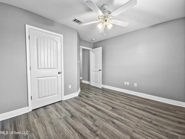 unfurnished bedroom with baseboards, a ceiling fan, wood finished floors, and visible vents