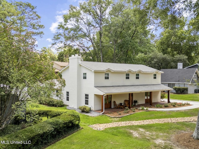 view of front of property with a chimney and a front lawn