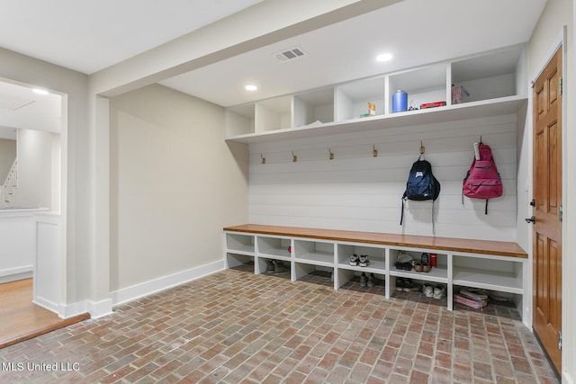 mudroom with brick floor, baseboards, visible vents, and recessed lighting