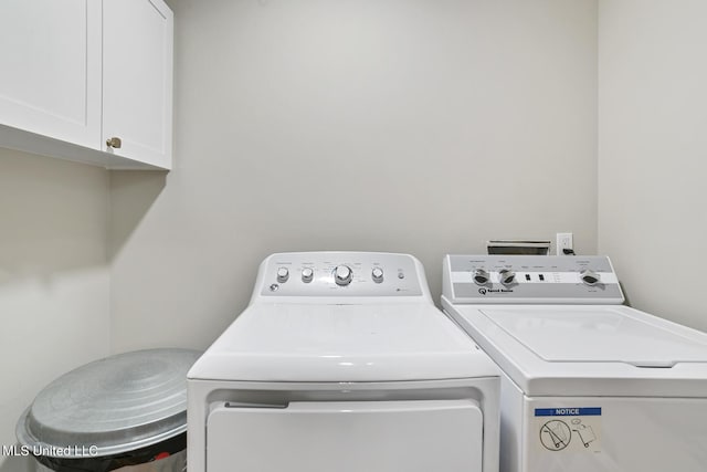 washroom with washer and clothes dryer and cabinet space