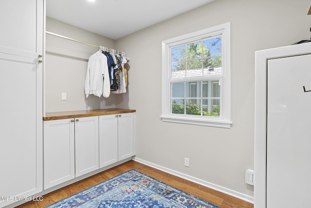 interior space featuring light wood-type flooring and baseboards