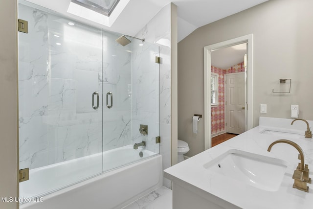 bathroom with double vanity, a skylight, marble finish floor, and a sink