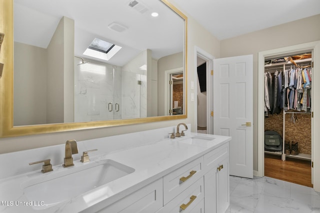 full bathroom with marble finish floor, a marble finish shower, a sink, and visible vents