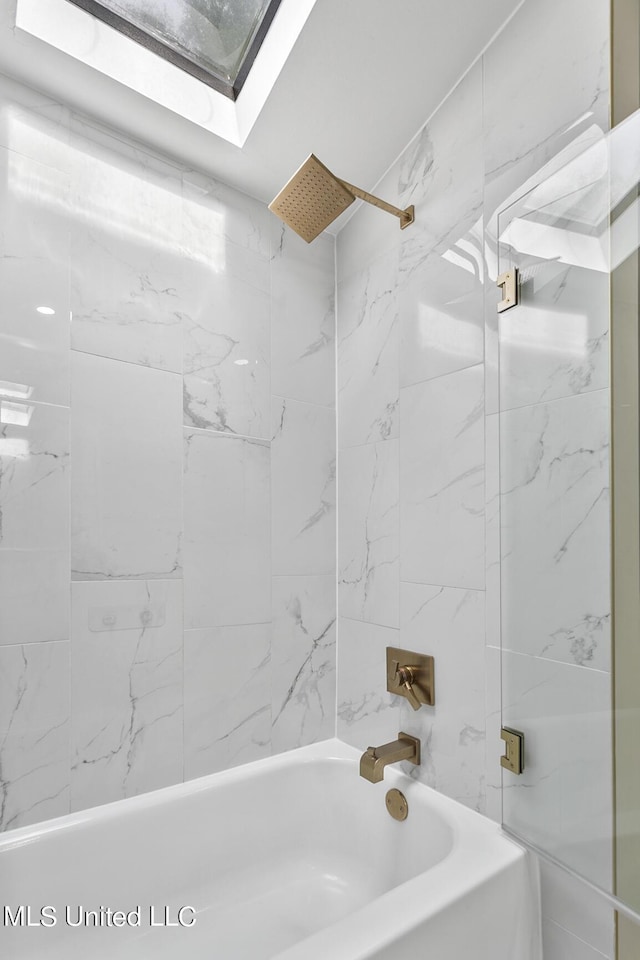 bathroom featuring a skylight and bathtub / shower combination