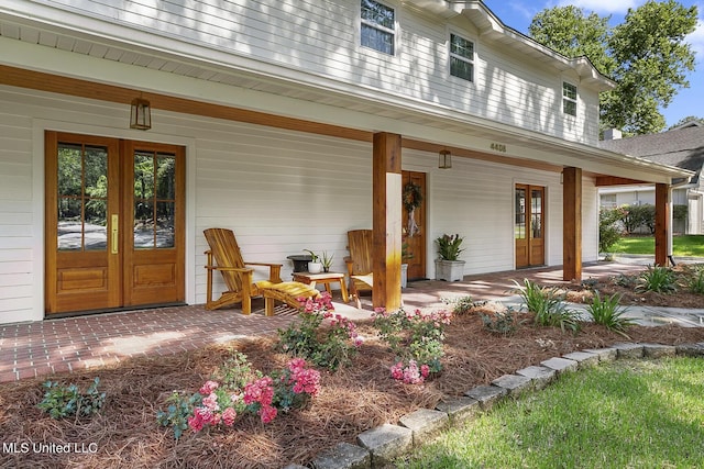 property entrance featuring covered porch and french doors