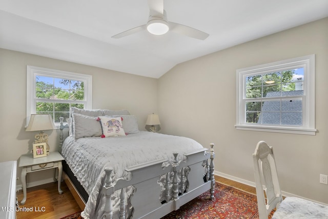 bedroom featuring a ceiling fan, baseboards, vaulted ceiling, and wood finished floors