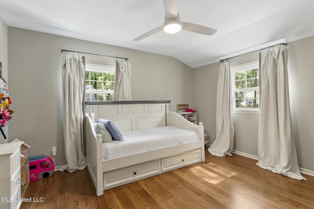 bedroom featuring lofted ceiling, light wood-style floors, and multiple windows