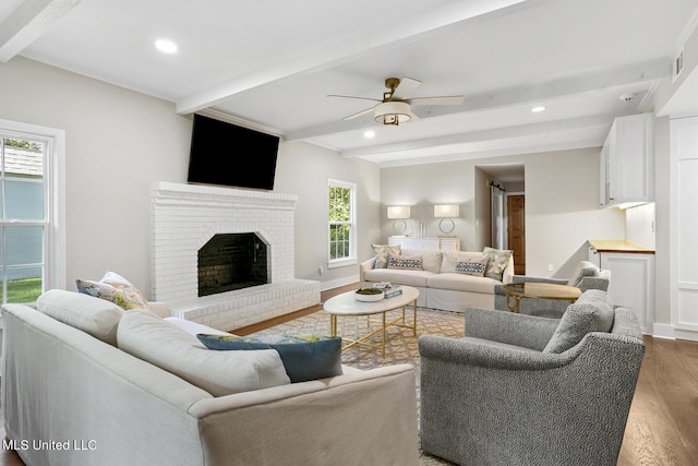 living room featuring a brick fireplace, wood finished floors, beam ceiling, and recessed lighting