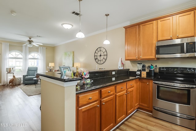 kitchen featuring a peninsula, brown cabinetry, appliances with stainless steel finishes, and crown molding