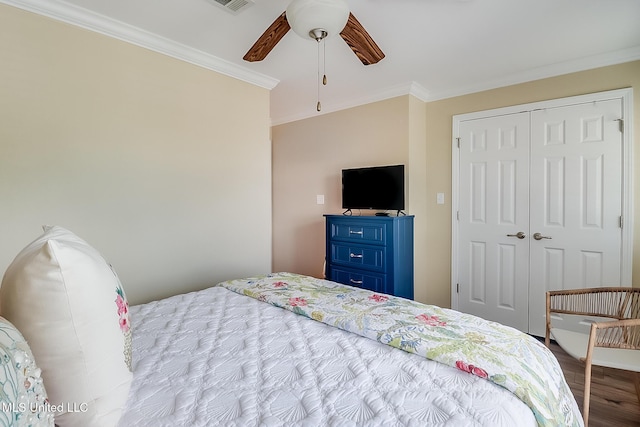 bedroom featuring wood finished floors, a closet, ceiling fan, and crown molding