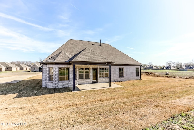 rear view of house with a patio and a lawn