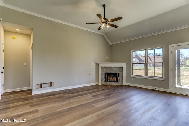 unfurnished living room featuring lofted ceiling, hardwood / wood-style floors, ceiling fan, a fireplace, and crown molding