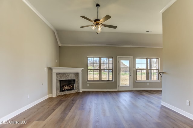 unfurnished living room featuring a fireplace, wood-type flooring, and plenty of natural light