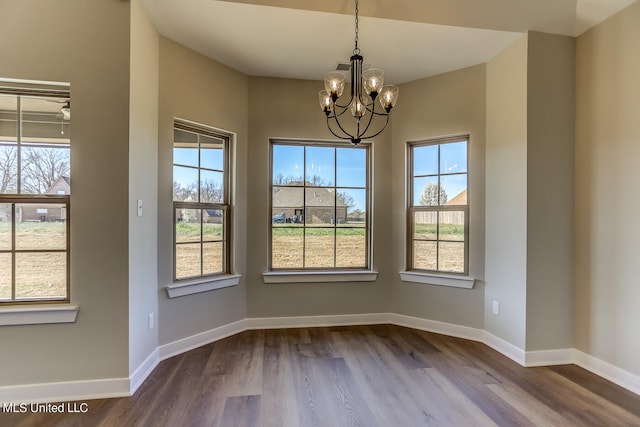 unfurnished dining area featuring hardwood / wood-style floors and a chandelier