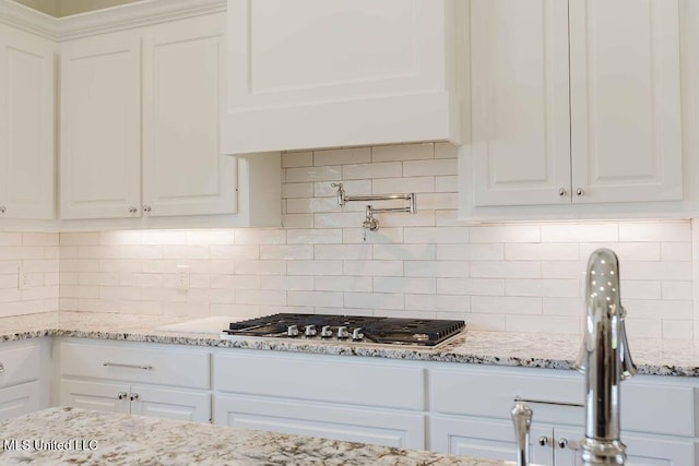 132 Freeland Ln, Clinton, MS 39056 - kitchen featuring white cabinetry, decorative backsplash, stainless steel gas stovetop, and light stone countertops