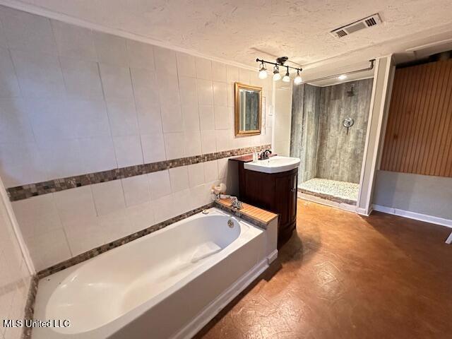 153 Saint Peter St, Biloxi, MS 39530 - bathroom with a shower stall, a bath, finished concrete floors, vanity, and a textured ceiling