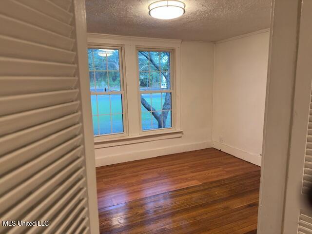 153 Saint Peter St, Biloxi, MS 39530 - spare room with a textured ceiling, dark wood finished floors, and baseboards