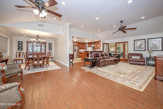 living room with ceiling fan, vaulted ceiling, healthy amount of natural light, a chandelier, and light wood finished floors