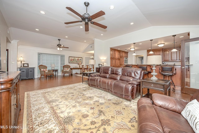 living area featuring vaulted ceiling, ceiling fan, ornamental molding, wood finished floors, and recessed lighting