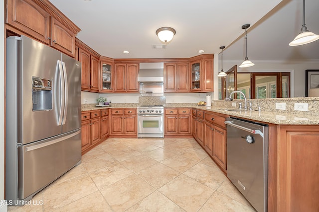 kitchen with stainless steel appliances, brown cabinets, a peninsula, wall chimney exhaust hood, and glass insert cabinets