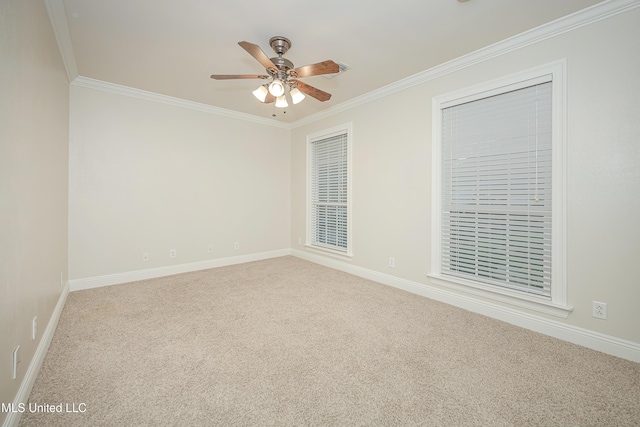 carpeted spare room with ornamental molding, a ceiling fan, and baseboards