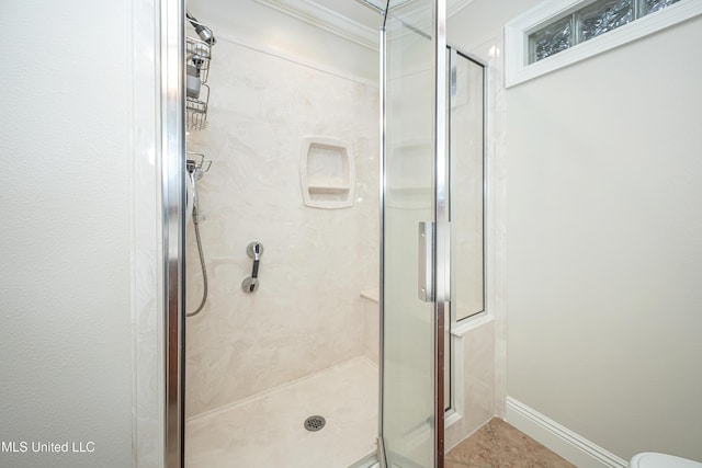 full bathroom featuring a shower stall, ornamental molding, and baseboards