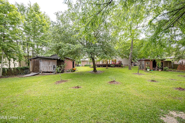 view of yard with a shed, an outbuilding, and a wooden deck