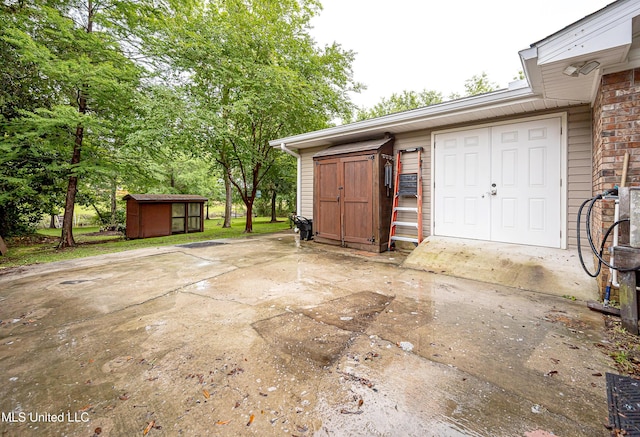 view of patio featuring a storage unit and an outbuilding
