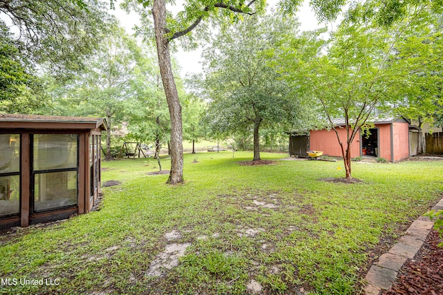 view of grassy yard featuring an outbuilding and a storage shed