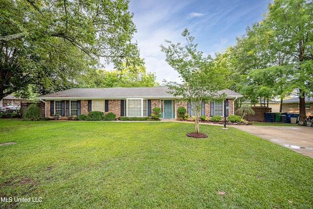 ranch-style home with brick siding, a front yard, and roof with shingles