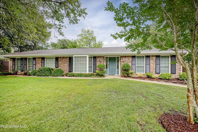 single story home featuring brick siding, a front yard, and a shingled roof