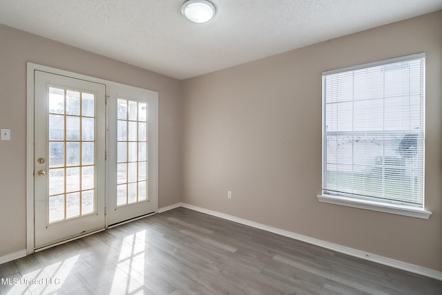 empty room featuring wood-type flooring and a textured ceiling