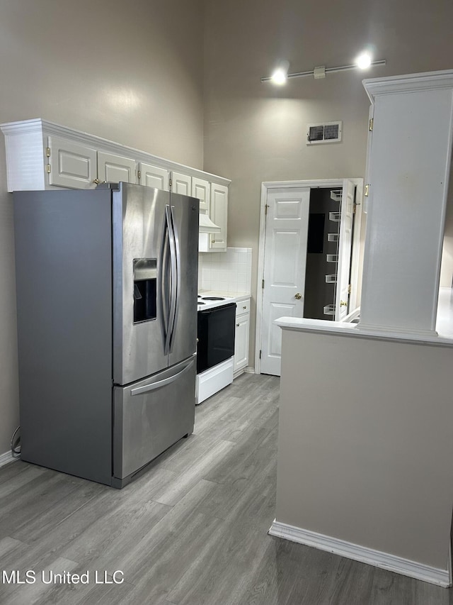 kitchen with white range with electric cooktop, stainless steel fridge with ice dispenser, white cabinets, and light wood-type flooring